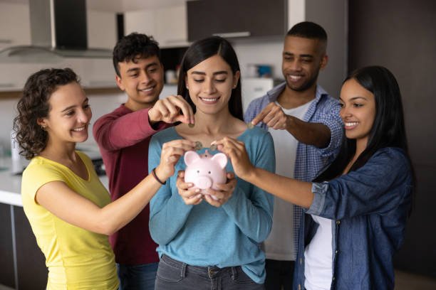 Friends putting money in a piggy bank together